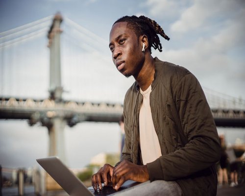 Person typing on laptop looking away for a brief break
