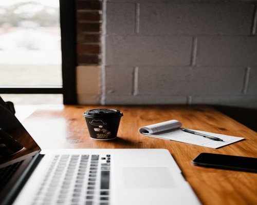 A workspace with a laptop and a warm cup of coffee